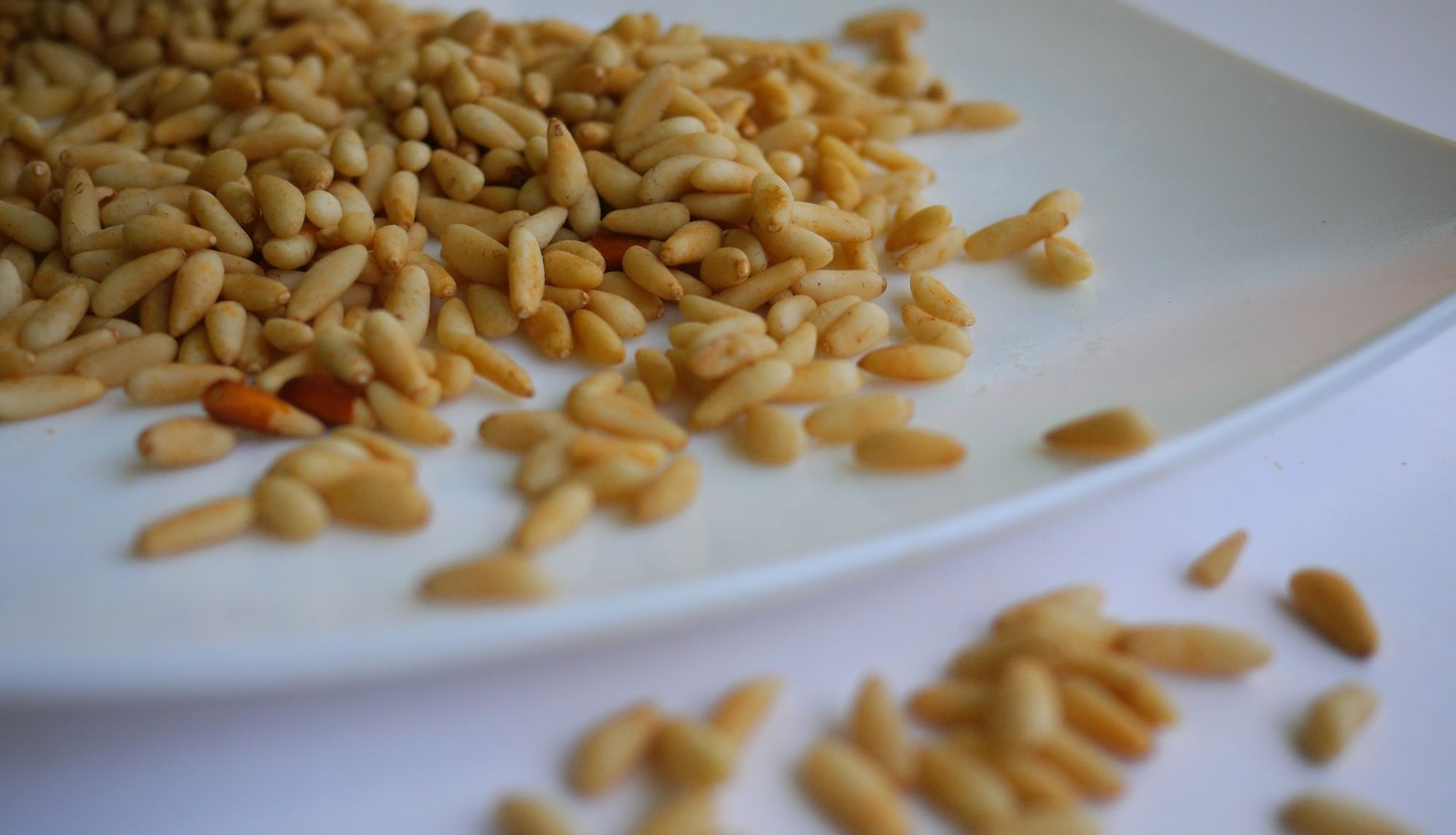 Pine Nuts on white ceramic plate