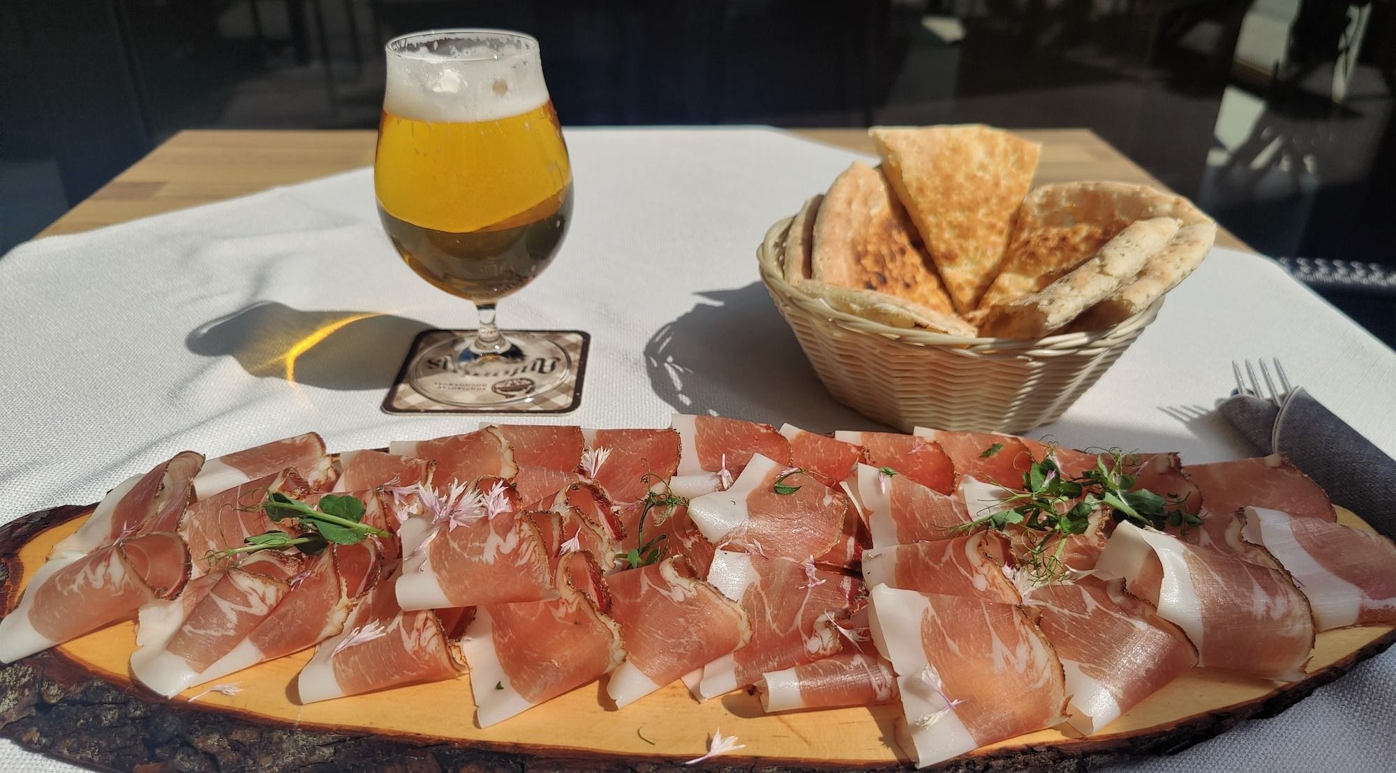 a platter of prosciutto, cheese and crackers on a table