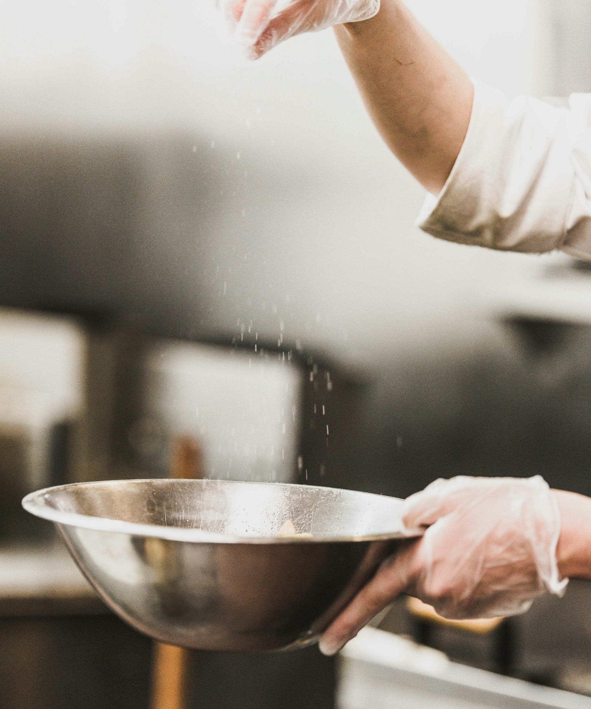 person garnishing on gray stainless steel bowl