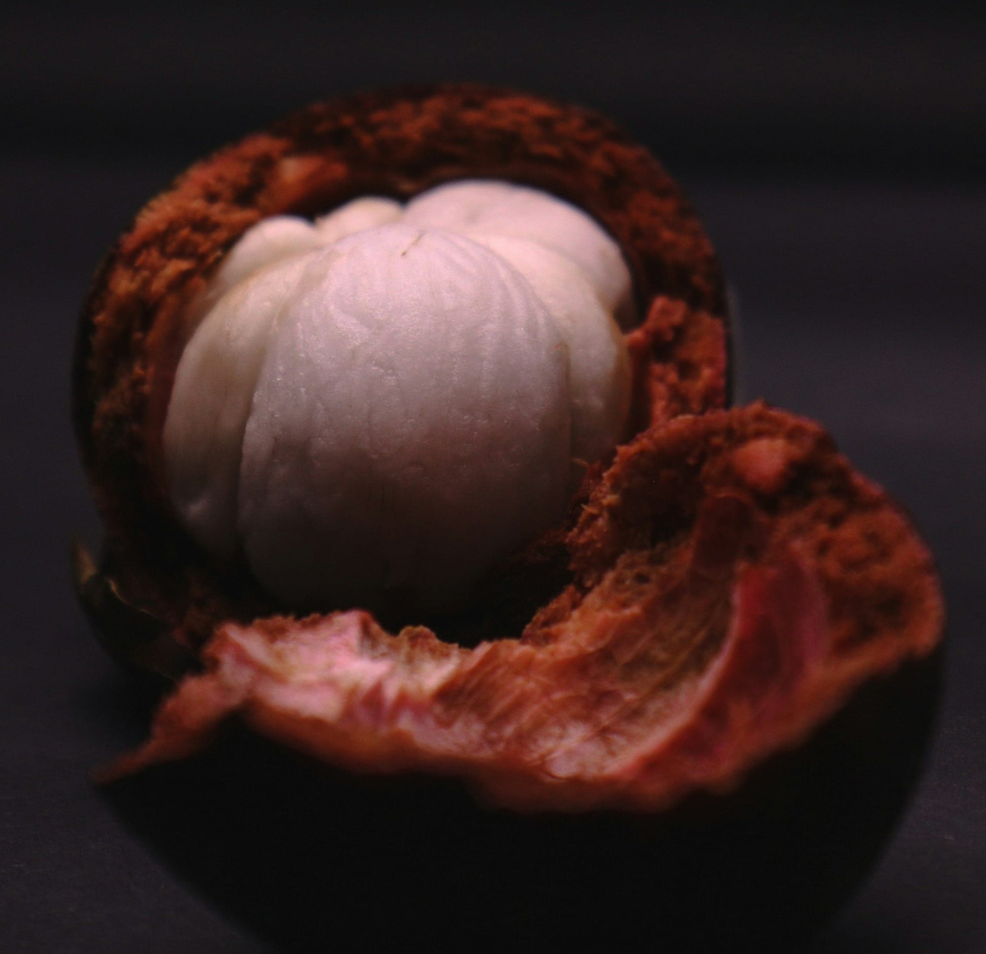 a white ball inside of an orange on a black surface
