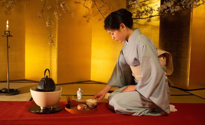 A lady in kimono preparing the matcha green tea